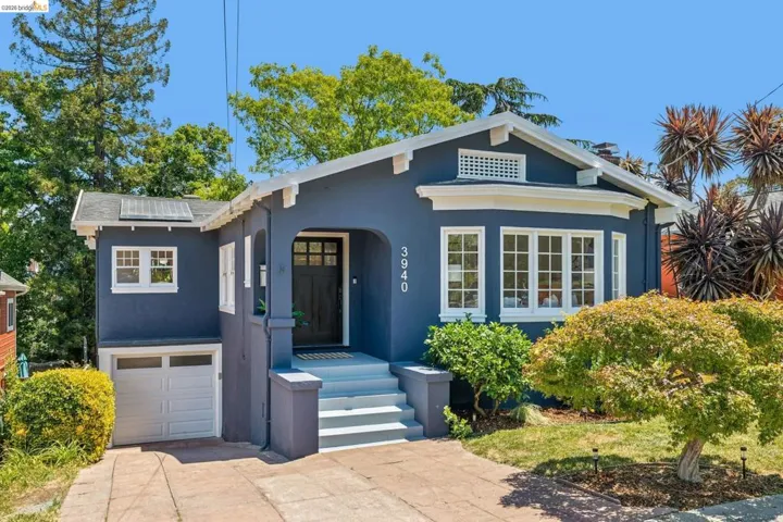 Charming bungalow-style residence featuring a distinctive bay window, front entry with covered porch, and exterior in a deep blue hue