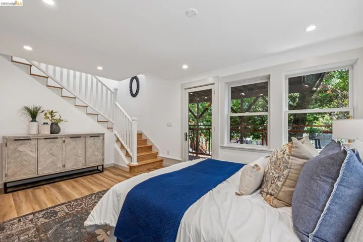 Bright interior with wood-finish flooring and a white painted staircase