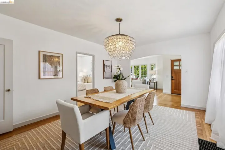 Dining area featuring a decorative chandelier, white walls, and wood-finish flooring
