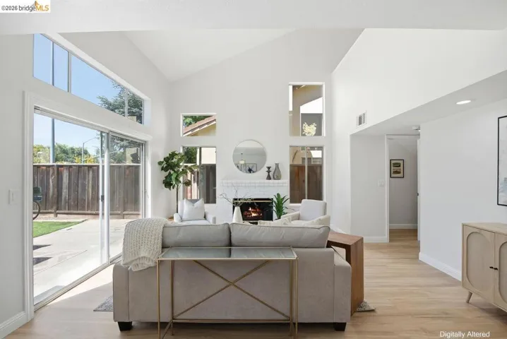 Vaulted ceiling with transom windows and a white brick fireplace