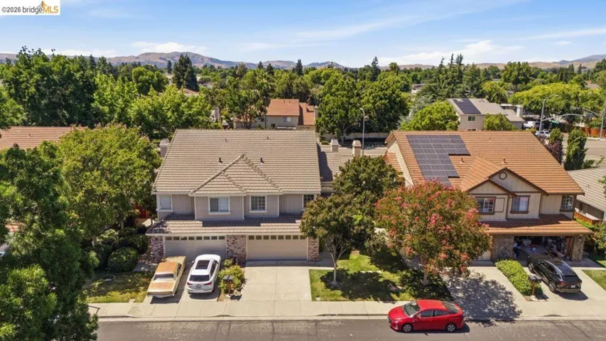 Suburban residence featuring a two-story design with a tile roof, an integrated two-car garage, and a concrete driveway