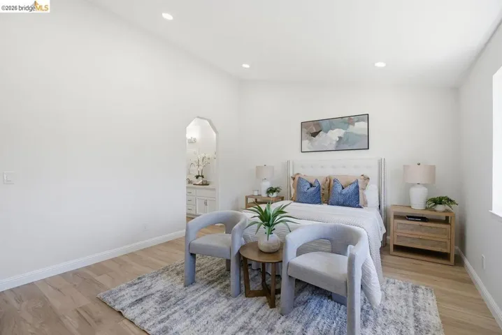 Recessed lighting illuminates this bright room featuring light wood-finish flooring and a window