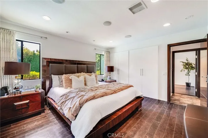 Primary Bedroom with Hardwood Floors, Recessed Lighting, Double Closets, and En Suite Full Bathroom