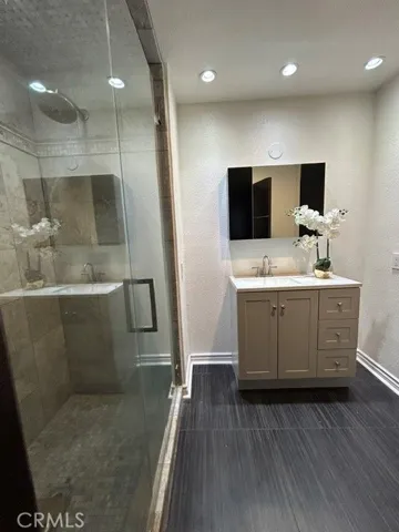 Remodeled Hall Bathroom with Italian Tile Floors, Stone Rain Shower, Seamless Glass Enclosure, and New Vanity