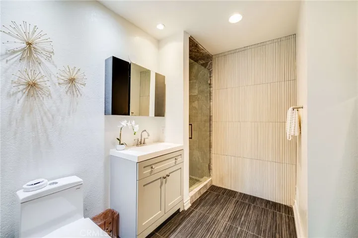 Primary En Suite Bathroom with Italian Tile Floors, New Vanity, and Stone Rain Shower