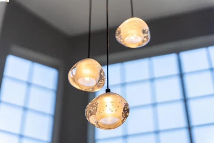 Three pendant lights with textured glass shades suspended from the ceiling