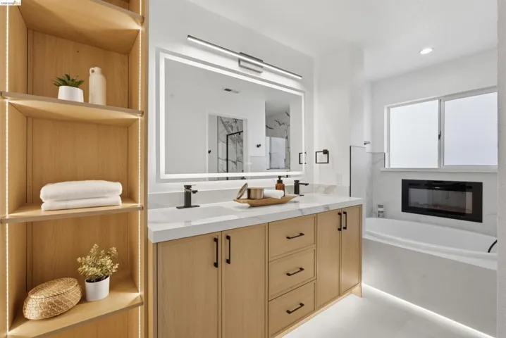 Dual vanity with light wood cabinetry, white quartz countertop, and matte black hardware