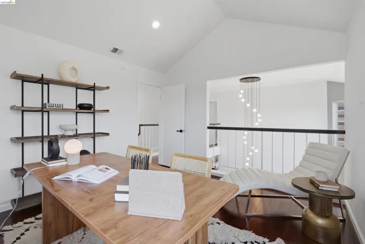 Vaulted ceiling loft space with wood-finish flooring