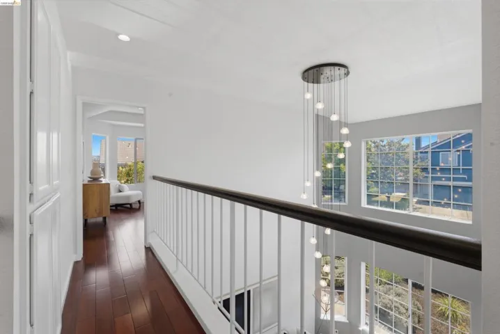 Second-story hallway featuring rich wood-finish flooring and built-in white cabinetry