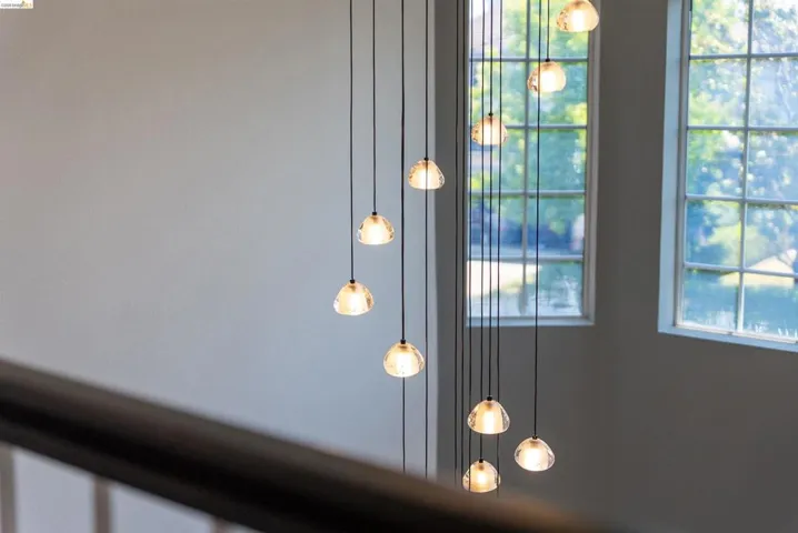 Multi-story lighting fixture featuring multiple pendant lights with clear glass shades