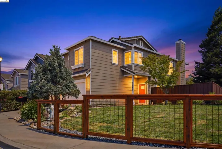 Contemporary two-story residence with a wood-finish fence and stone landscaping