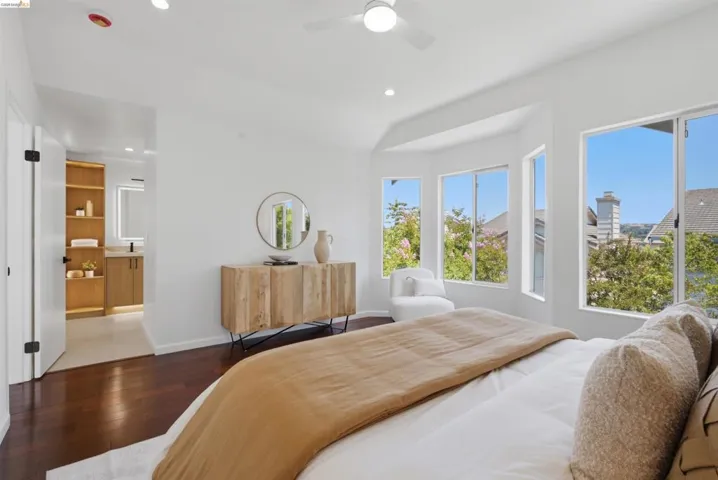 Bright interior space featuring dark wood-finish flooring and a white ceiling fan