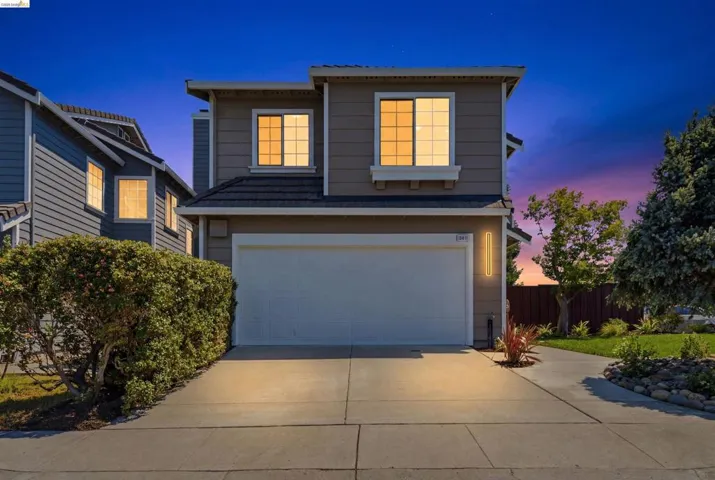 Two-story residence featuring a two-car garage, concrete driveway, and established landscaping