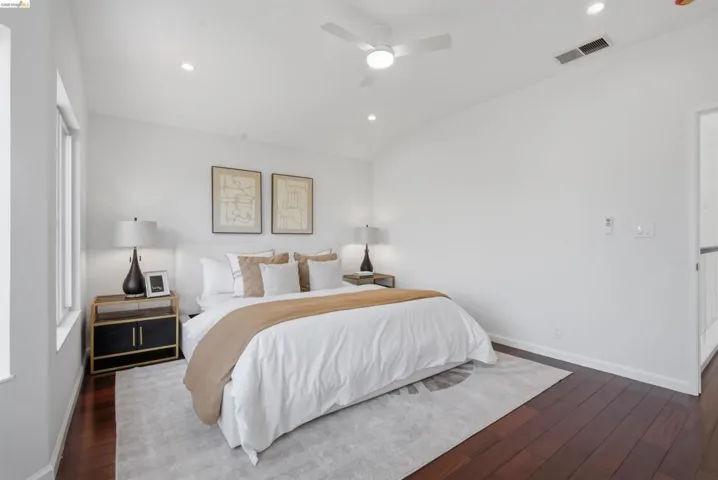 Bedroom featuring rich wood-finish flooring and bright white walls