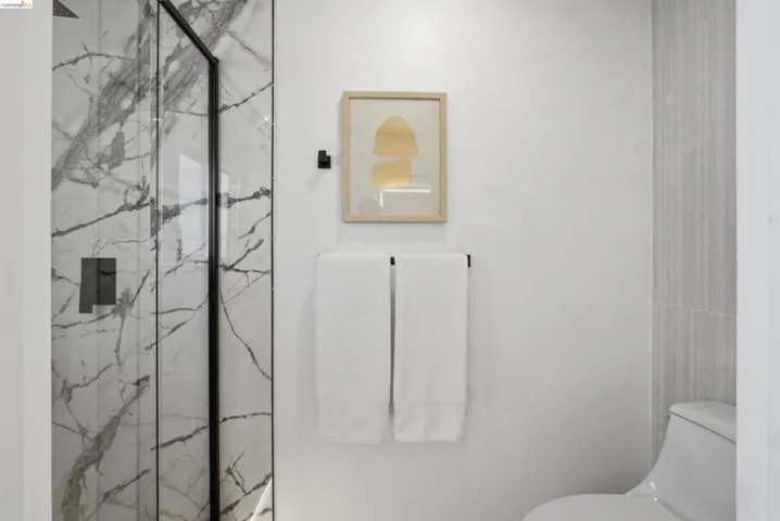 Shower enclosure with black framing and marbled tile surround