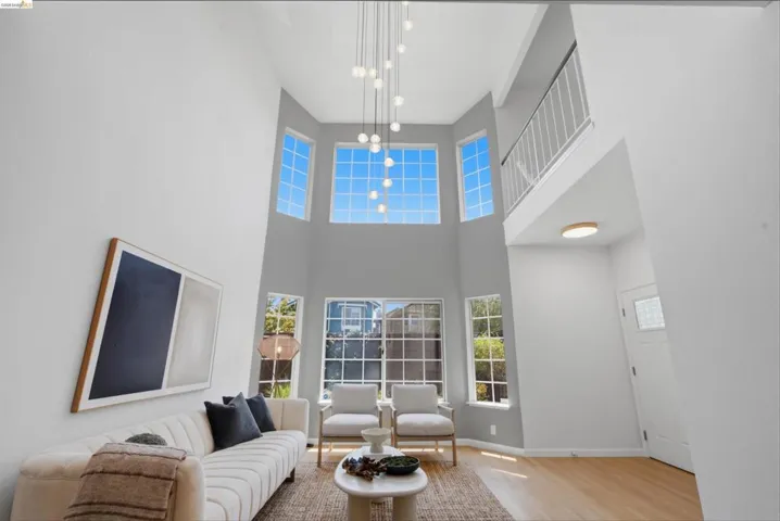 Soaring ceilings with an elegant multi-tier chandelier and abundant natural light from numerous windows