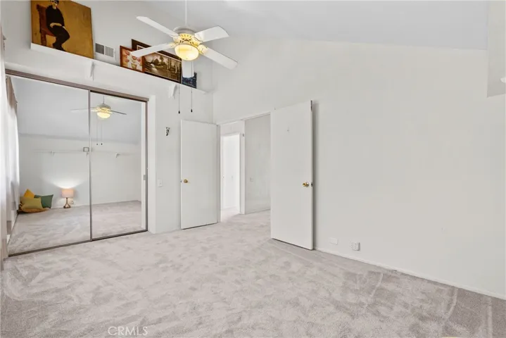 second bedroom with double doors and ceiling fan