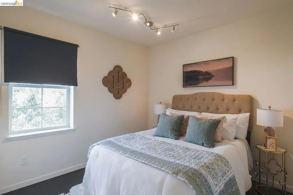 Cream-toned walls featuring a single window with a dark roller shade