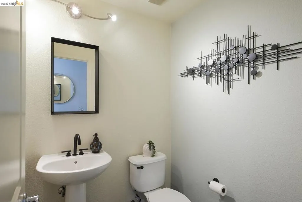 Bathroom featuring a pedestal sink, matte black faucet, and a rectangular mirror with a black frame