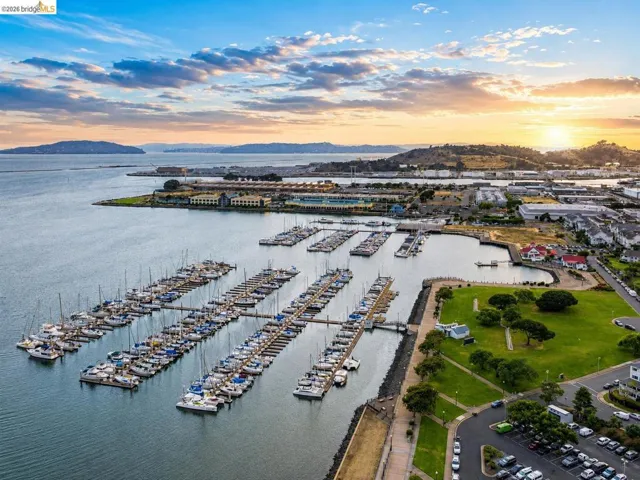 Marina with multiple boat slips, surrounded by waterfront parkland and residential buildings