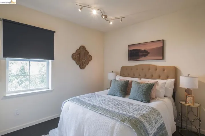 Cream-toned walls featuring a single window with a dark roller shade