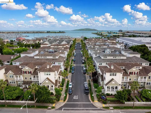 Community of multi-story residences featuring varied exterior siding, gabled rooflines, and covered front porches