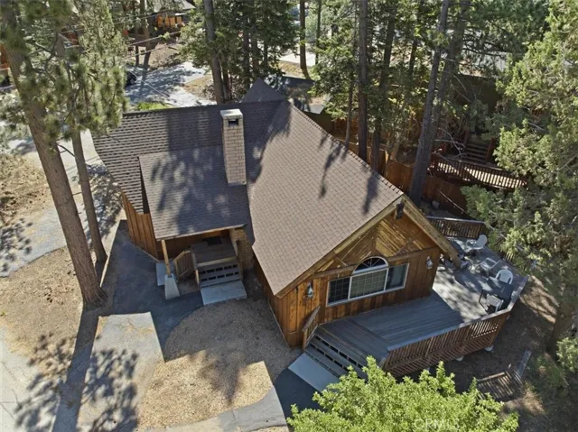 Aerial view showing the cabin roofline, deck, and surrounding trees.