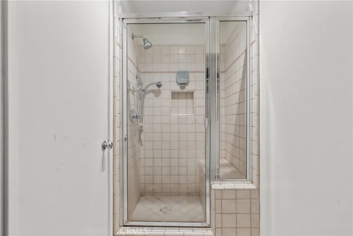 Walk in primary shower with bench seat.