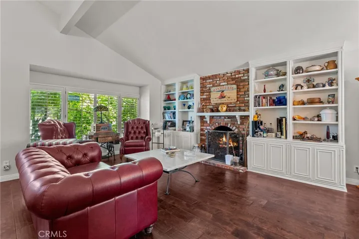 Living room with vaulted ceilings and fireplace.