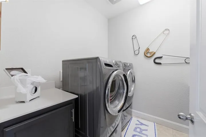 Laundry area featuring washer and dryer and a textured wall