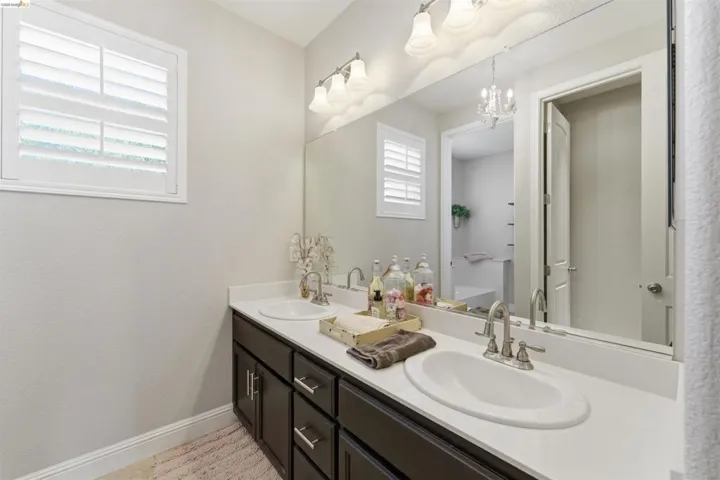 Bathroom featuring double vanity and a chandelier