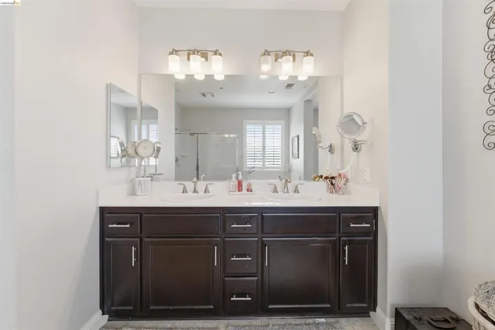Bathroom with double vanity and a stall shower