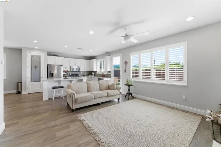 Living room featuring a ceiling fan, light wood-style flooring, and recessed lighting