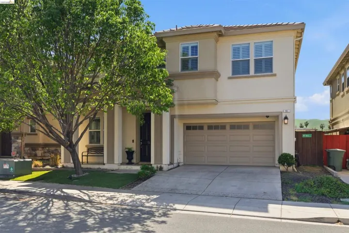 View of front of property with a garage, stucco siding, driveway, and a tile roof