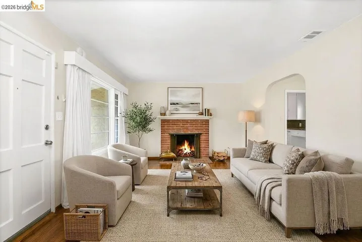 Living room featuring a brick fireplace with wood flooring
