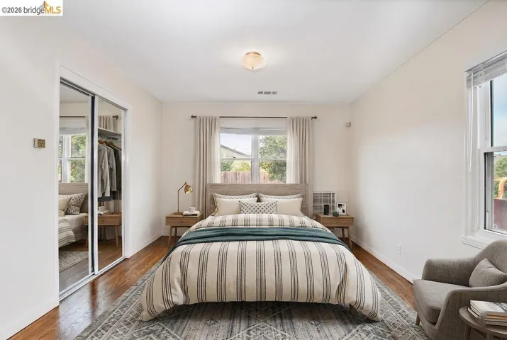 Room featuring wood-finish flooring, two windows with window treatments, and a ceiling-mounted light fixture