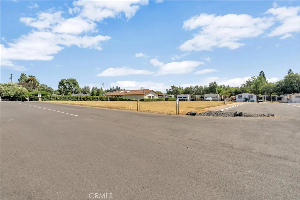 View from front of large open geen area and plentry of guest parking