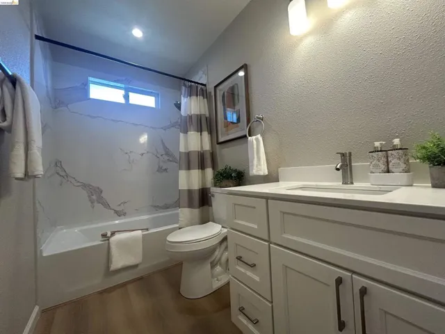 Bathroom featuring a white vanity with shaker-style cabinetry, a white countertop, and a stainless steel faucet