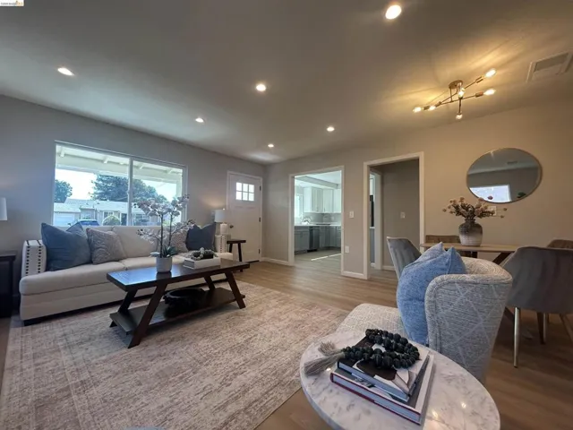 Living area featuring wood-finish flooring, recessed lighting, and a modern chandelier