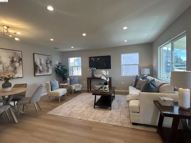 Open-concept living space featuring wood-finish flooring, recessed lighting, and ample natural light from multiple windows