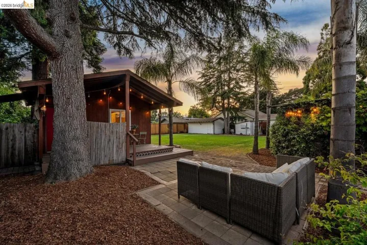Detached structure featuring a covered porch, wood-finish siding, and string lighting