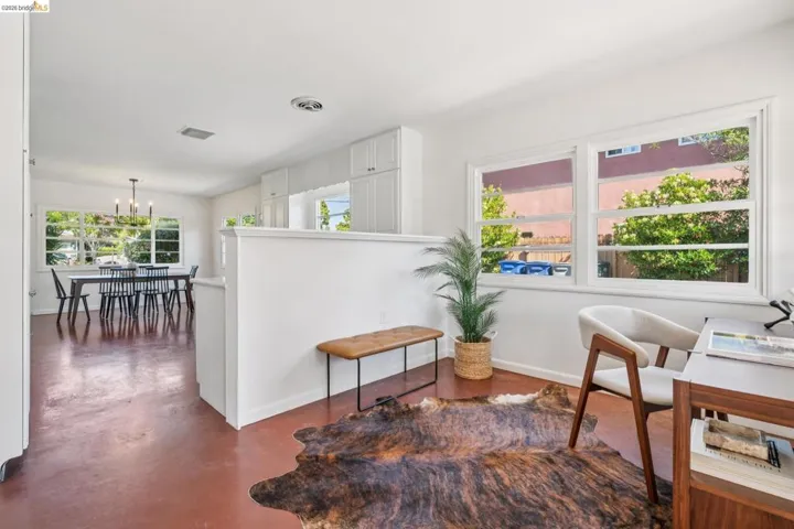 Versatile interior space featuring rich red-toned flooring and white walls