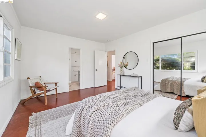 Bright interior featuring warm-toned flooring, white walls, and a window with natural light