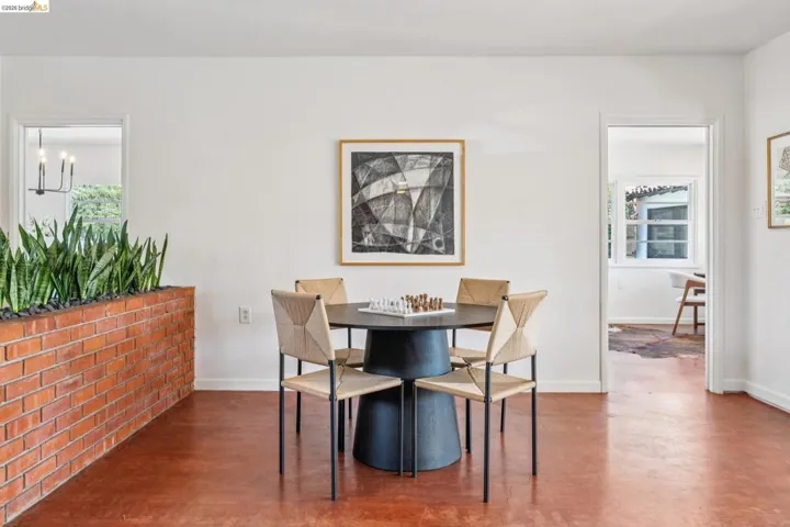 Interior space featuring a brick planter wall, white walls, and warm-toned flooring