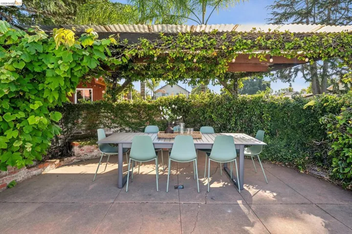 Expansive outdoor patio featuring a concrete surface and mature landscaping