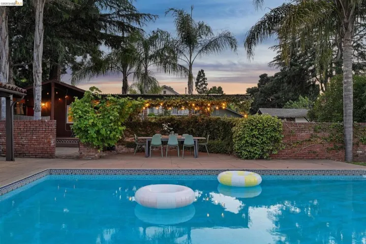 Rectangular swimming pool featuring a patterned tile border and surrounding concrete decking