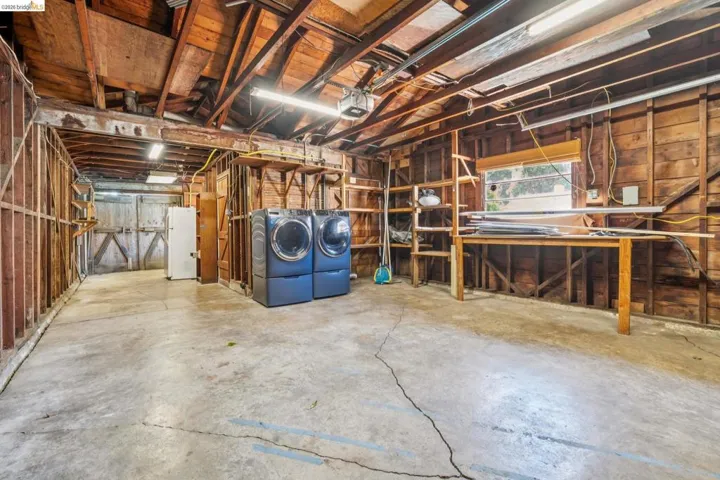 Concrete flooring garage with exposed wood framing and ceiling beams