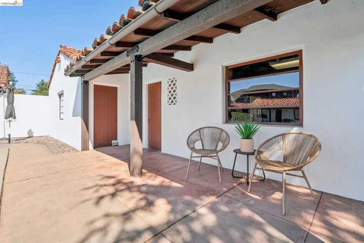Stucco exterior with a terracotta tile roof and exposed wood beams