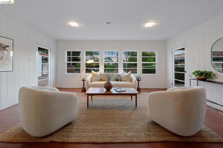 Spacious room featuring multiple windowpanes and white paneled walls