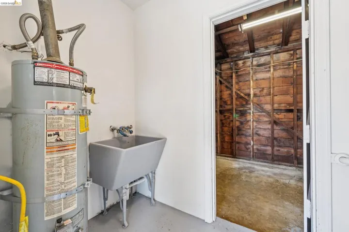 Utility area with a water heater and a freestanding utility sink